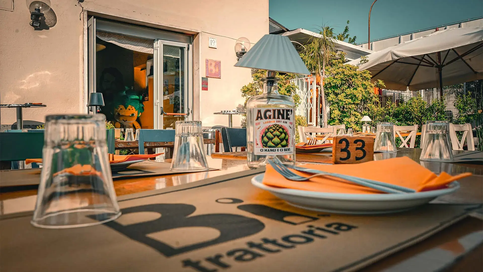 Esterno del ristorante con tavoli immersi nel verde